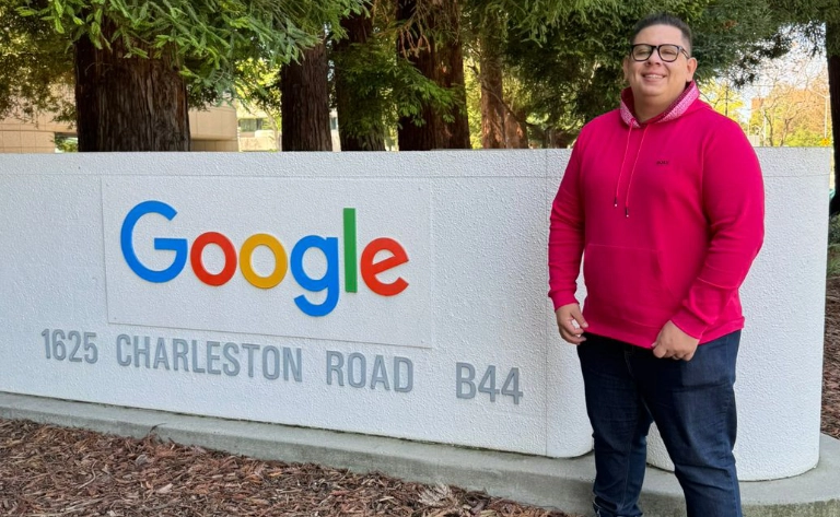 Renan Santos ao lado de uma placa do Google em uma área externa